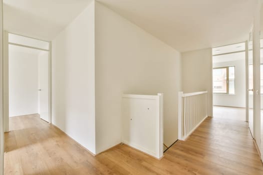 A spacious, minimalistic hallway featuring clean lines, natural light, and wooden flooring, emphasizing modern interior design principles.