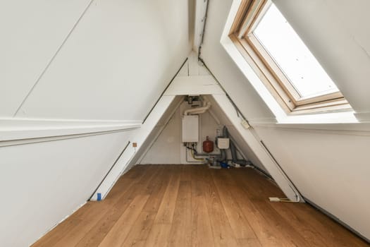 A contemporary interior space showcasing clean lines, wooden flooring, and a skylight. The design emphasizes simplicity and natural light.
