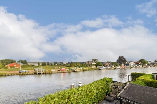 Explore a picturesque riverside scene featuring vibrant greenery, calm water, and charming houses, perfect for a tranquil getaway.