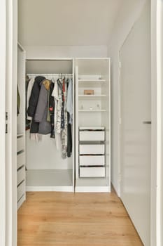 A sleek modern wardrobe showcases organized clothing and shelving, enhancing the functionality of interior spaces with minimalist aesthetics.