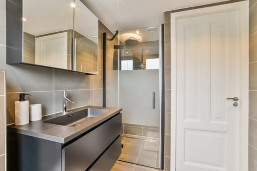 A contemporary bathroom featuring a walk-in shower, stylish sink, and elegant lighting, showcasing modern design elements and functionality.