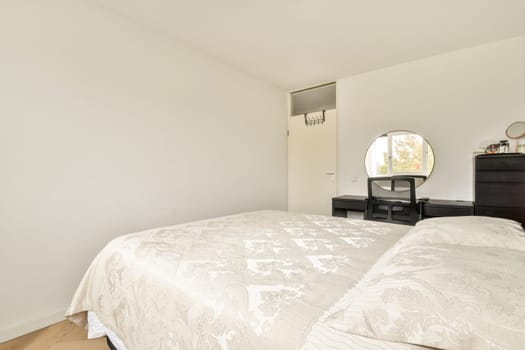 A spacious modern bedroom featuring a light color palette, elegant decor, and minimalistic furniture that enhances the room's tranquility.