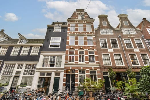 A picturesque view of traditional Amsterdam buildings featuring decorative facades and bicycles parked outside, reflecting the city's unique charm and vibrant lifestyle.