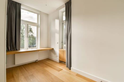 Bright and airy room featuring elegant window design, soft curtains, and wooden flooring, creating a serene and modern living space.