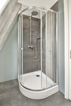 A sleek, modern shower enclosure features glass panels and minimalistic design, enhancing the contemporary feel of the bathroom with neutral tones.