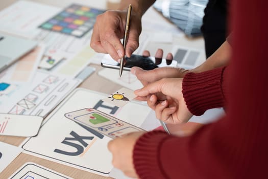 Colleagues collaborate on UX UI design concepts, sharing ideas and taking notes while reviewing wireframes and prototypes in a creative workspace.