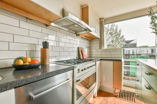 A beautifully designed modern kitchen featuring sleek cabinets, a stainless steel oven, and a bright window with a view. Perfect for culinary enthusiasts.