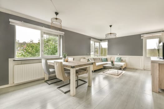 A spacious modern living room featuring stylish furnishings, large windows allowing natural light, and a cozy ambiance, perfect for relaxation and gatherings.