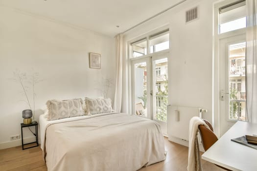 A serene and stylish bedroom featuring a cozy bed, soft textiles, and large windows that flood the space with natural light. Perfect for relaxation.