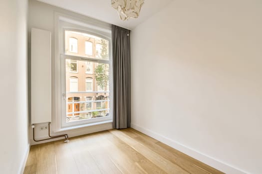 A sleek and airy interior space featuring large windows and soft natural light, enhancing the minimalist design of the room.