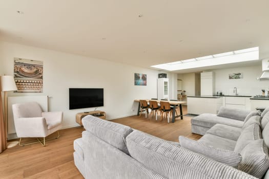 A spacious and modern living room featuring a cozy seating area, open kitchen design, and contemporary decor for an inviting atmosphere.