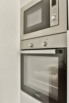 A sleek modern kitchen featuring a combination microwave and oven unit. The stainless steel finish complements the contemporary design of the kitchen space.