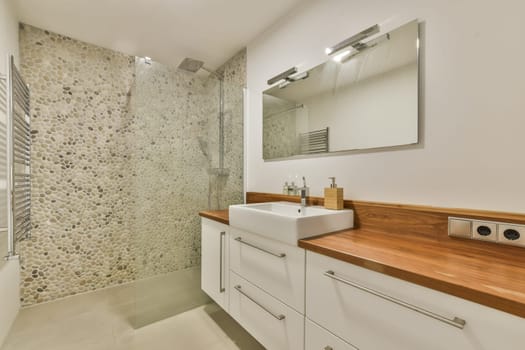 Elegant modern bathroom featuring a sleek sink, wooden accents, and a stylish tile wall, creating a tranquil ambiance suitable for relaxation.