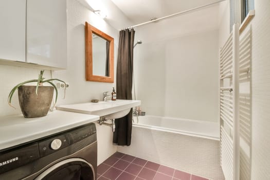 A contemporary bathroom featuring a washing machine, sleek cabinetry, and neutral color tones, creating a functional yet stylish space for relaxation.