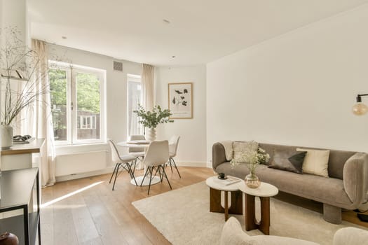 A spacious and stylish living room featuring natural light, elegant furniture, and a calm color palette, perfect for relaxation and social gatherings.
