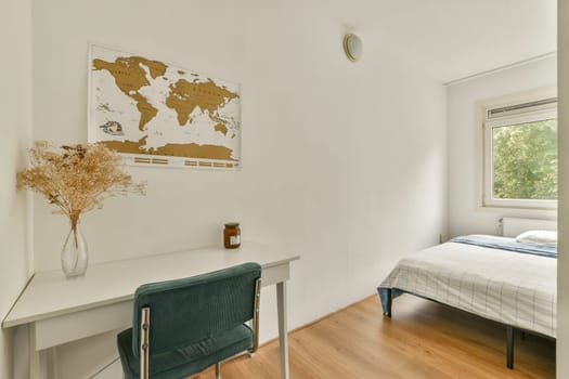 A serene bedroom featuring a world map on the wall, a simple desk, and a neatly made bed, creating a comfortable and stylish atmosphere for relaxation.