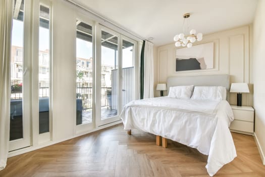 A beautifully designed modern bedroom featuring large windows, stylish lighting, and elegant furnishings, creating a serene and inviting atmosphere.
