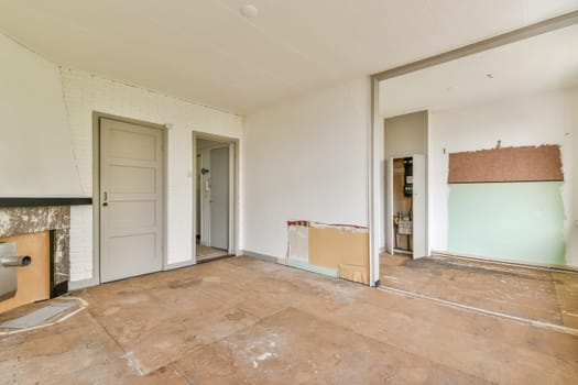 This image showcases an empty interior undergoing renovation. The walls are bare, with some areas prepared for finishing touches. The flooring appears unfinished.