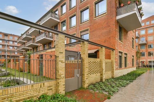 A contemporary apartment building features stylish architecture with balconies and integrated green areas, promoting urban living in a sustainable environment.