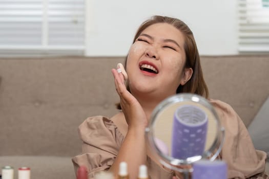 A woman indulges in her skincare ritual, smiling brightly as she applies moisturizer on her face, showcasing happiness and the importance of self-care.