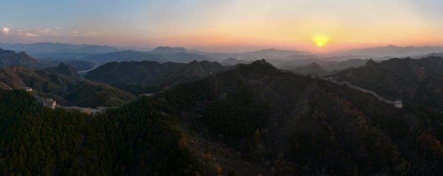 Stunning, non-AI, real drone pano shot of the sun setting over the UNESCO, famous Great Wall of China. Jinshanling section, Beijing. Shot with DJI Mavic Pro 3