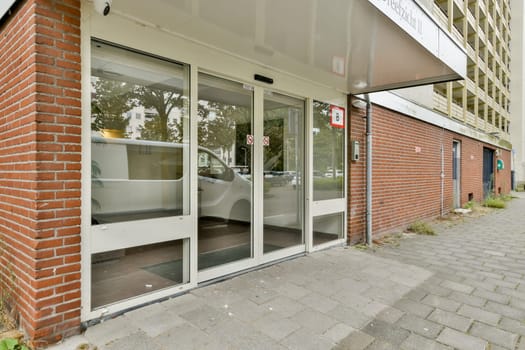 A sleek, modern entrance featuring automatic sliding doors and brick detailing, designed for easy access. A clean urban setting enhances the appeal.