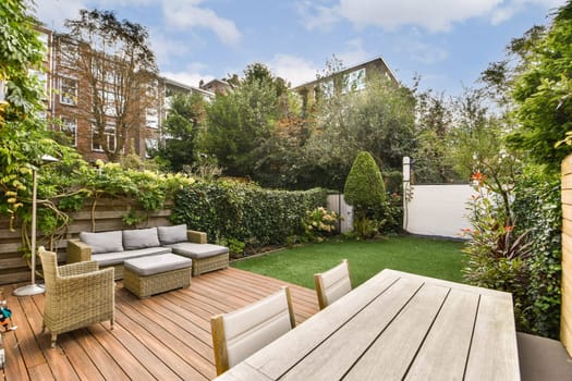 A beautifully designed modern garden featuring a green lawn, stylish outdoor seating, and lush plants that create a tranquil retreat.