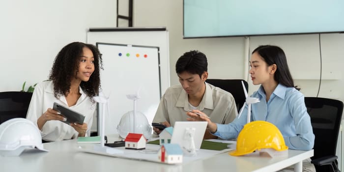 A strategic meeting takes place as professionals discuss the integration of green energy principles into modern engineering.