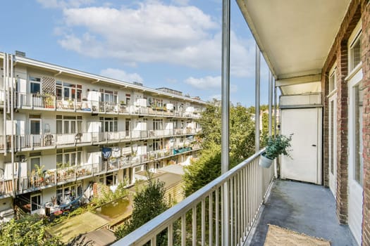 A stunning view from a modern apartment balcony showcasing nearby buildings and clear blue skies, highlighting residential architecture and greenery.