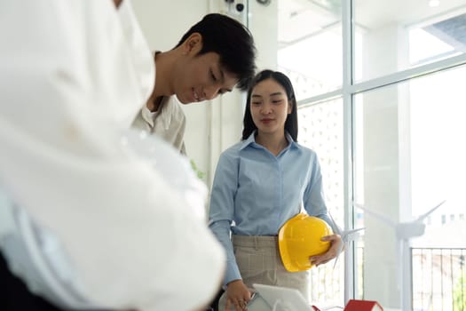 Engaged in a teamwork environment, professionals explore layers of sustainable design, weighing its impact on future projects.