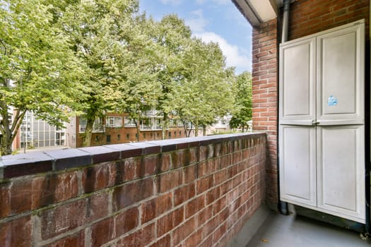 A contemporary balcony scene featuring a brick railing, greenery, and urban architecture in the background creating a vibrant living space.