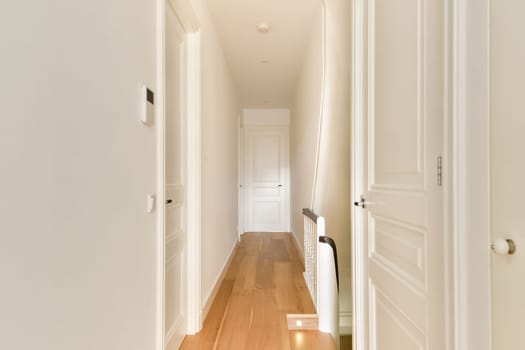 A sleek and minimalist indoor hallway featuring clean lines, wooden flooring, and bright light creating an inviting atmosphere.