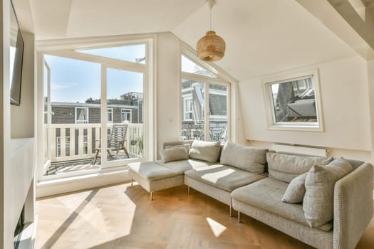 A contemporary living space featuring a cozy sofa, ample natural light from large windows, and a stylish design that invites relaxation and comfort.