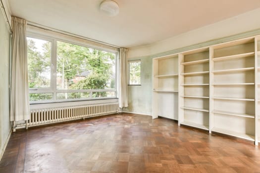 A bright and airy empty room showcasing large windows and wooden flooring. The space is perfect for creative ideas and design transformations.
