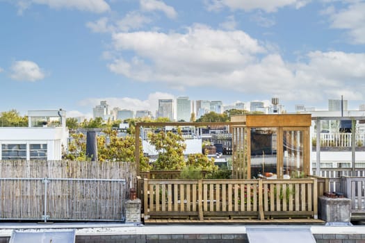 A beautifully designed rooftop garden featuring wooden elements, greenery, and a stunning skyline view of a modern city. Ideal for relaxation and urban escape.