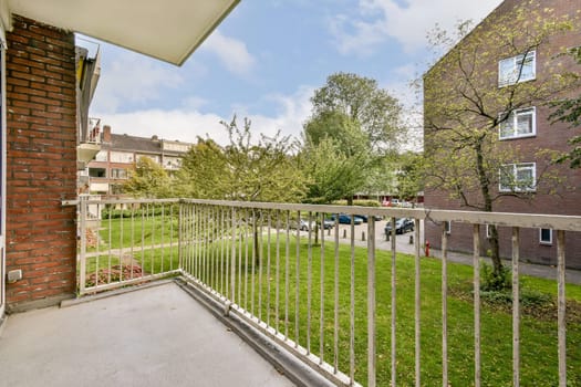 A serene view from a modern apartment balcony overlooking lush greenery, providing a refreshing outdoor space amid an urban environment.