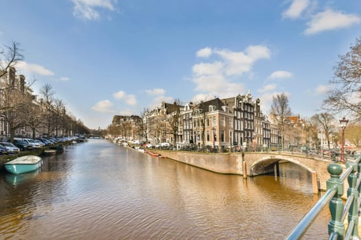 Picturesque scene featuring traditional Dutch buildings alongside a calm canal, enhancing the beauty of Amsterdam's urban landscape.