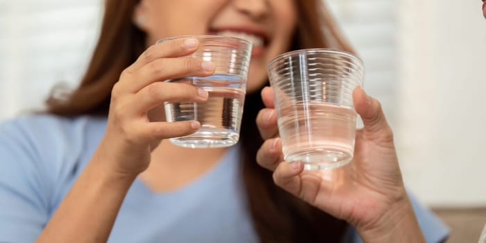 A joyful moment captured between a mother and her child as they raise their glasses of water, emphasizing the significance of hydration and health in their daily lives.