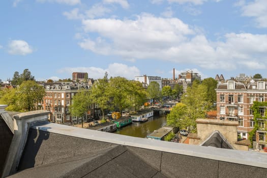 The image showcases a picturesque aerial view of Amsterdam, featuring its iconic canals, lush greenery, and charming historic architecture.