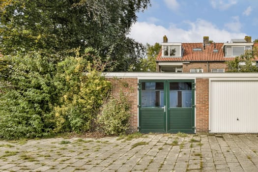 A picturesque scene showcasing a charming brick house surrounded by lush greenery and a clear blue sky. The house features a welcoming design with green doors.
