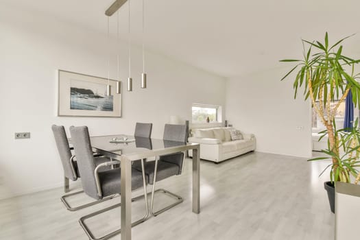 A sleek dining area featuring a modern table and chairs along with decorative plants, creating a fresh and inviting atmosphere.