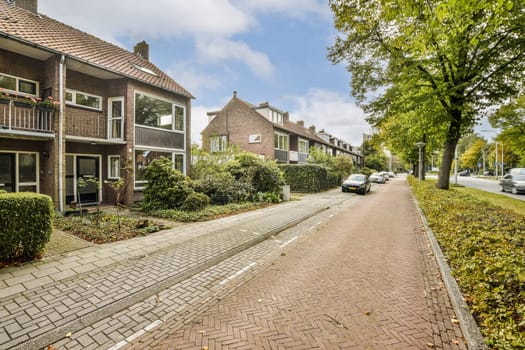 A picturesque view of a neighborhood featuring well-maintained houses, vibrant plants, and a peaceful street, perfect for leisurely strolls and community life.