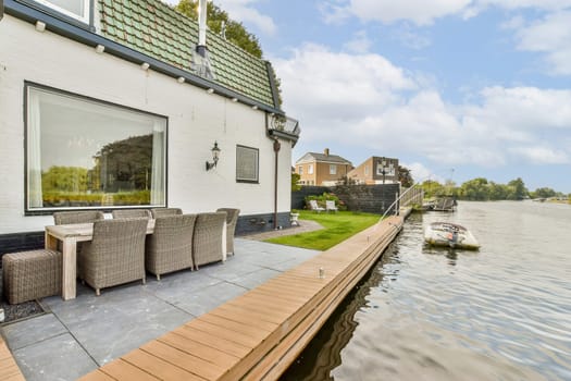A beautiful waterfront property featuring a spacious patio and outdoor seating, ideal for relaxation by the water's edge, surrounded by serene landscaping.