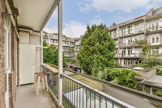 A serene balcony view showcasing lush trees and urban architecture, blending nature with city living in a peaceful setting.