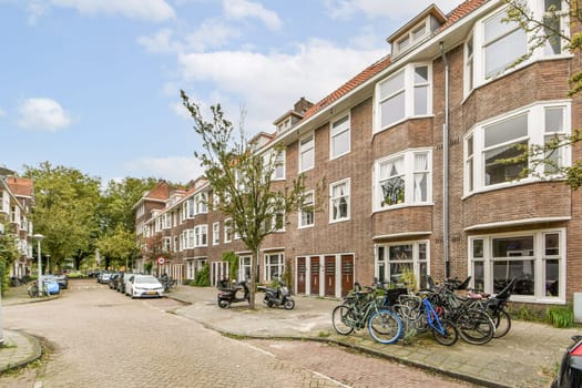 A picturesque view of a charming residential street lined with classic brick buildings and bicycles parked along the road, surrounded by trees.