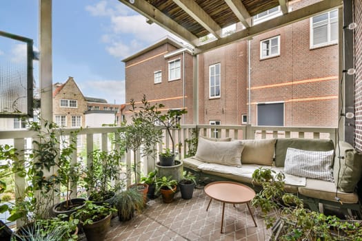 A charming balcony featuring comfortable seating, a stylish table, and an array of potted plants, creating a serene outdoor living space.