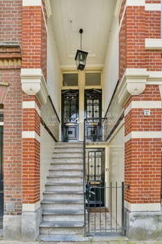 A beautifully designed entrance featuring classic brick architecture, elegant stairway, and intricate door details, showcasing the charm of historic buildings.