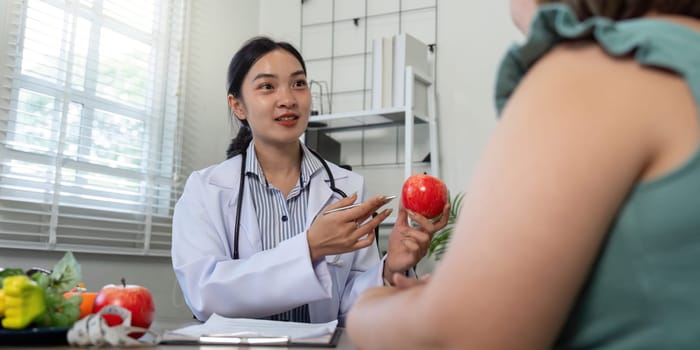 The nutritionist engages with a client, explaining the benefits of healthy food choices while highlighting the significance of personalized dietary plans during a consultation.