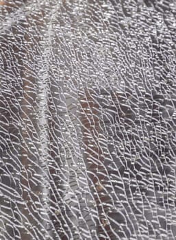 Newcastle, UK - Apr 11, 2025 - Detail of broken tempered glass pane too many small irregular shape pieces holding together. Texture of cracked broken glass cracked by impact, Cracks on the glass surface background, use it as your Wallpaper, Poster and Space for text, Selective focus.
