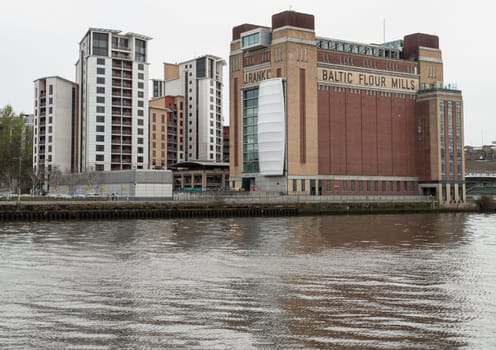 Newcastle, UK - Apr 12, 2025 - Stunning view of Baltic Flour Mills is Centre for Contemporary Art and other buildings at Gateshead Quayside by the River Tyne. converted from a former flour mill in Newcastle upon tyne, use it as your Wallpaper, Poster and Space for text, Selective focus.